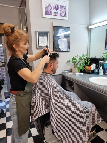 A team member cutting a client’s hair in the chair