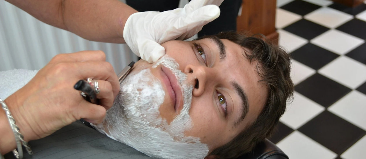 A client receiving a hot towel wet shave